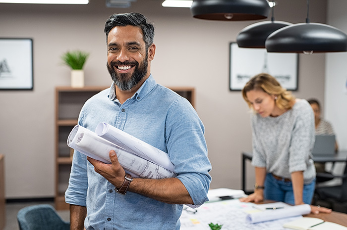 man and woman in small office smiling while working